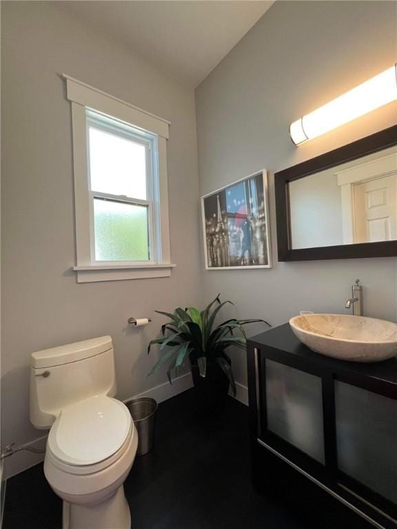 bathroom with vanity, toilet, and baseboards