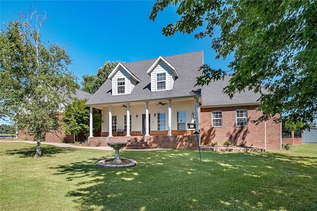 cape cod house with a front yard, ceiling fan, and covered porch