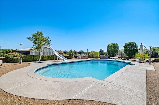 view of swimming pool with a patio area and a water slide