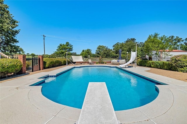 view of pool with a patio area, a diving board, and a water slide