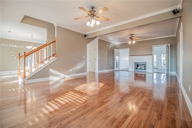 unfurnished living room with crown molding, ceiling fan with notable chandelier, and light hardwood / wood-style flooring