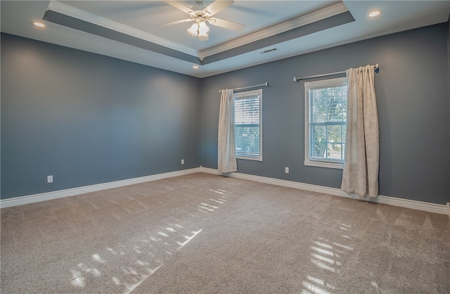 unfurnished room featuring a tray ceiling, ornamental molding, ceiling fan, and carpet flooring