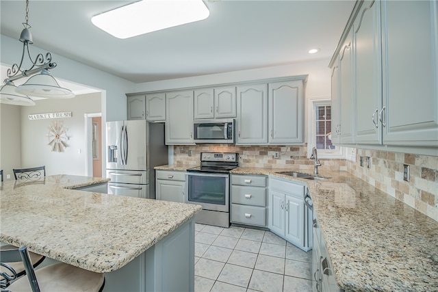 kitchen with sink, decorative light fixtures, a kitchen island, stainless steel appliances, and decorative backsplash