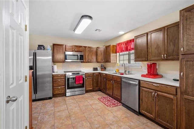 kitchen with light tile patterned floors, appliances with stainless steel finishes, and sink