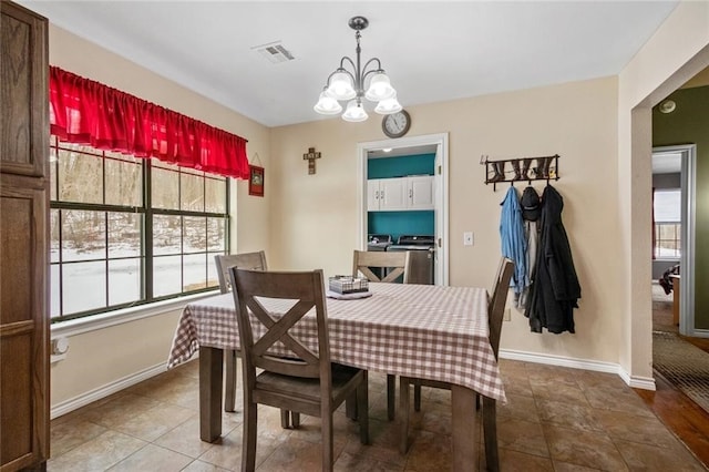 tiled dining space with a chandelier