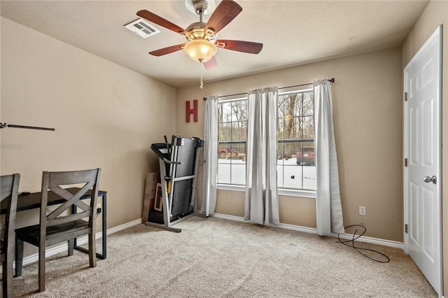 carpeted office space featuring ceiling fan