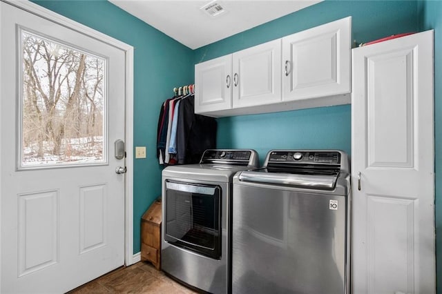 clothes washing area with light tile patterned flooring, washer and clothes dryer, and cabinets