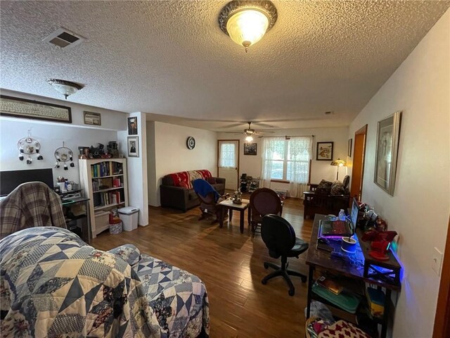 living room featuring a textured ceiling, ceiling fan, and hardwood / wood-style floors