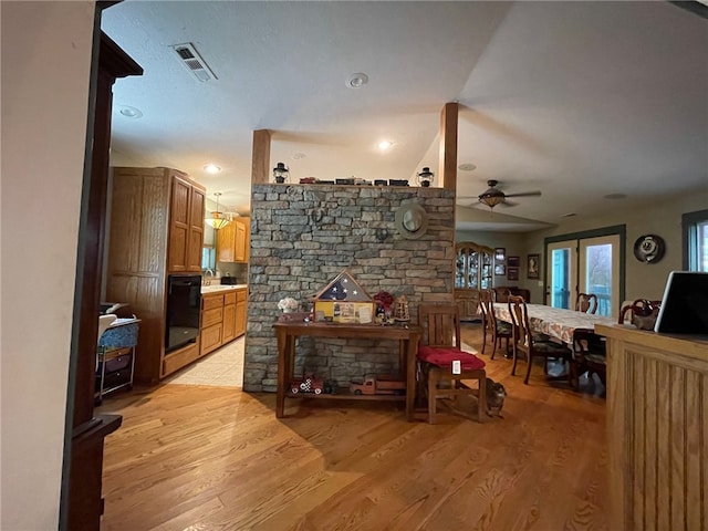 living room featuring french doors, light wood-type flooring, and ceiling fan