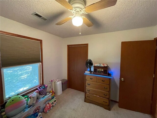 interior space featuring light carpet, a textured ceiling, and ceiling fan