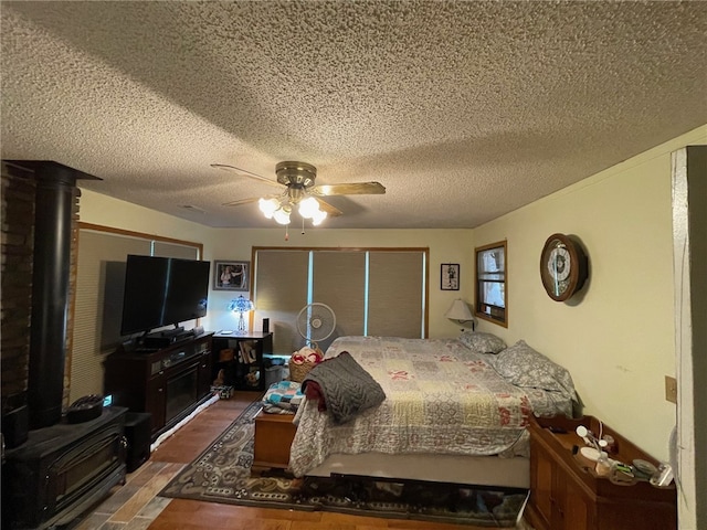 bedroom with wood-type flooring, a textured ceiling, and ceiling fan