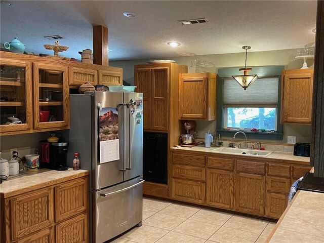 kitchen with high quality fridge, tile counters, light tile patterned floors, hanging light fixtures, and sink