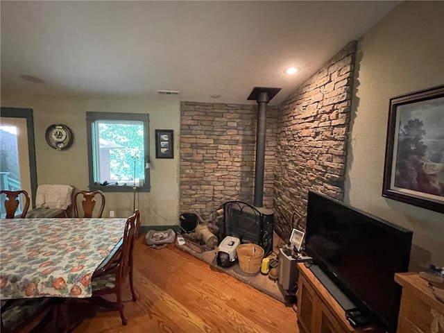 dining area featuring hardwood / wood-style flooring and a wood stove