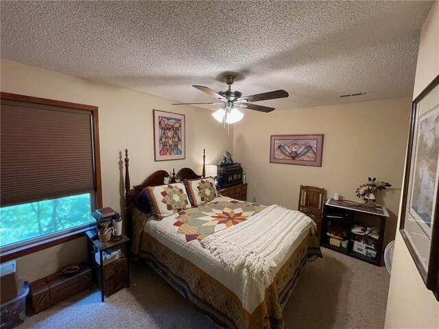 bedroom featuring a textured ceiling, carpet, and ceiling fan