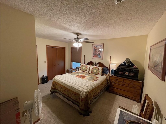 carpeted bedroom featuring ceiling fan, a closet, and a textured ceiling