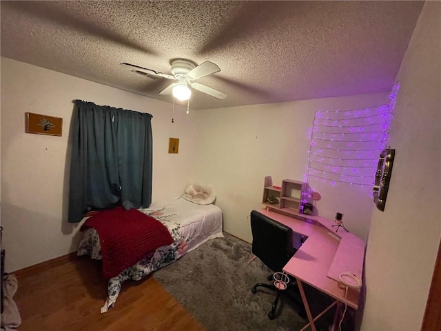 bedroom with hardwood / wood-style floors, a textured ceiling, and ceiling fan