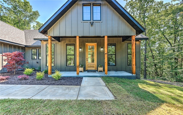 doorway to property featuring a yard and covered porch