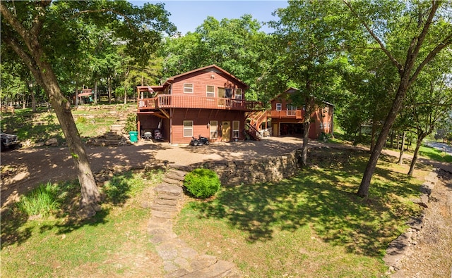 back of house featuring a wooden deck and a yard