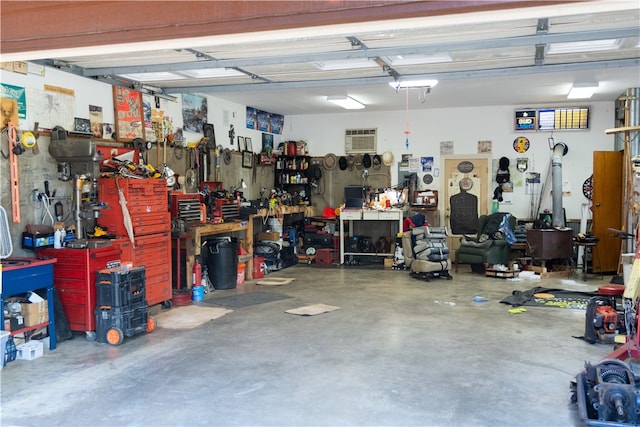 garage with an AC wall unit and a workshop area