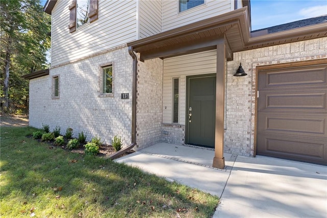 property entrance with a garage and a lawn