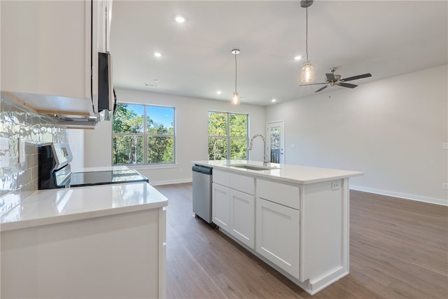 kitchen featuring sink, appliances with stainless steel finishes, white cabinetry, an island with sink, and decorative light fixtures