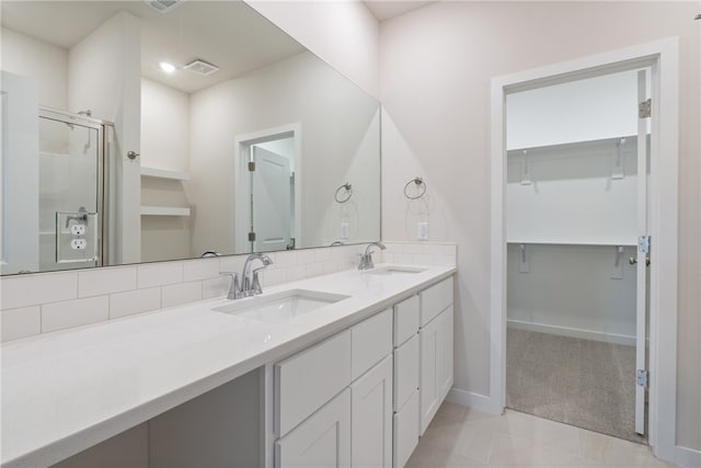 bathroom with vanity, walk in shower, tile patterned floors, and decorative backsplash