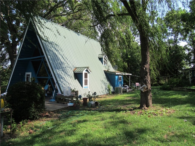 exterior space with central AC, a deck, and a yard