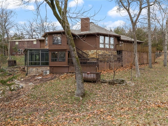 back of house featuring a wooden deck and a sunroom