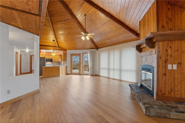 unfurnished living room with wooden ceiling, a stone fireplace, light hardwood / wood-style flooring, ceiling fan, and beamed ceiling