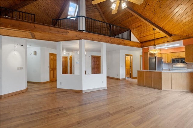 kitchen featuring stainless steel fridge, light hardwood / wood-style flooring, and high vaulted ceiling