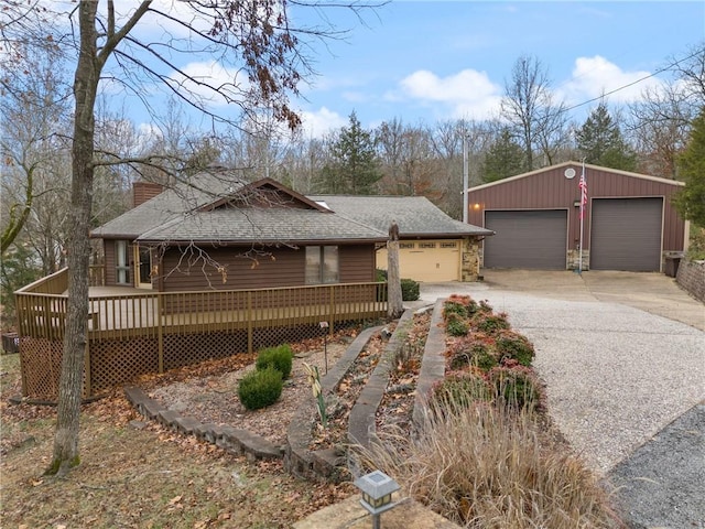 view of front of property with an outdoor structure, a deck, and a garage