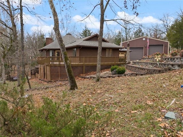 exterior space featuring a wooden deck, an outdoor structure, and a garage