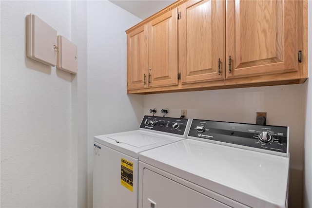 laundry room with washer and dryer and cabinets