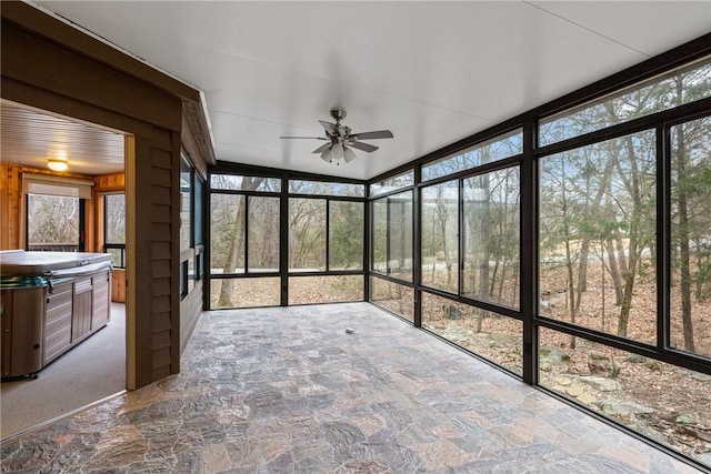 unfurnished sunroom featuring ceiling fan