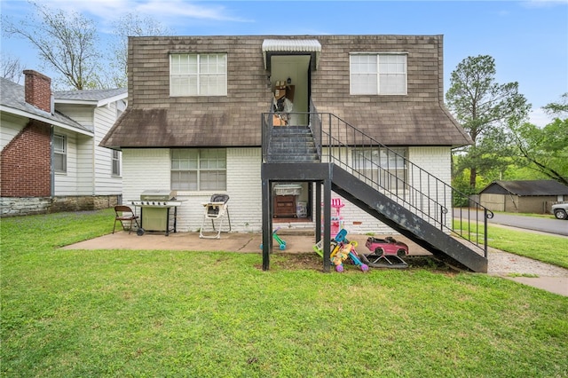 rear view of property with a shingled roof, brick siding, stairway, and mansard roof