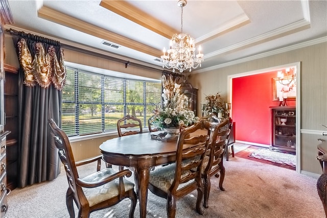 carpeted dining room featuring crown molding, a tray ceiling, and a notable chandelier