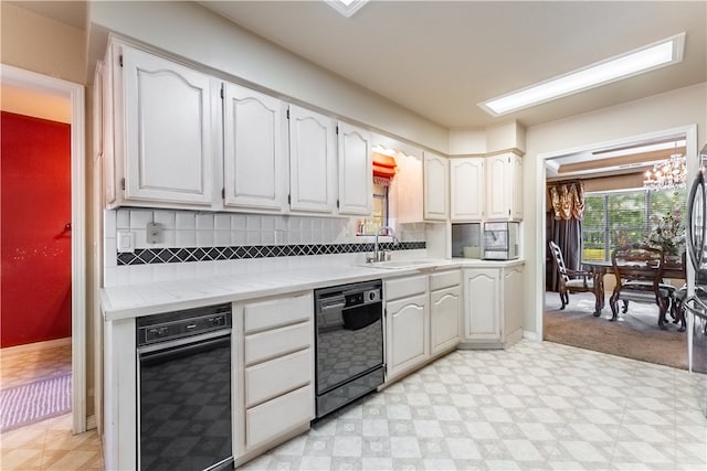 kitchen featuring a notable chandelier, backsplash, black dishwasher, light carpet, and sink