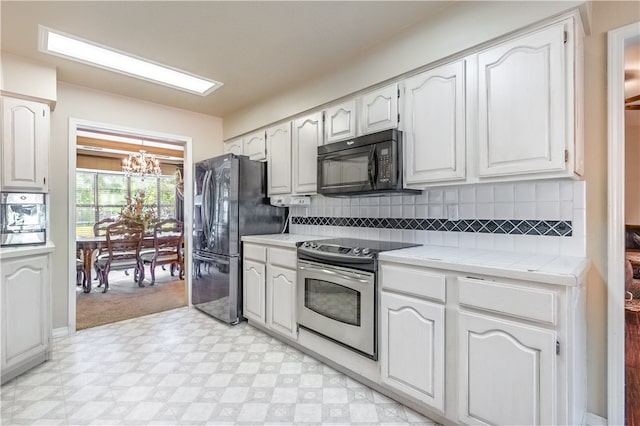 kitchen featuring white cabinetry, backsplash, black appliances, and light tile patterned floors