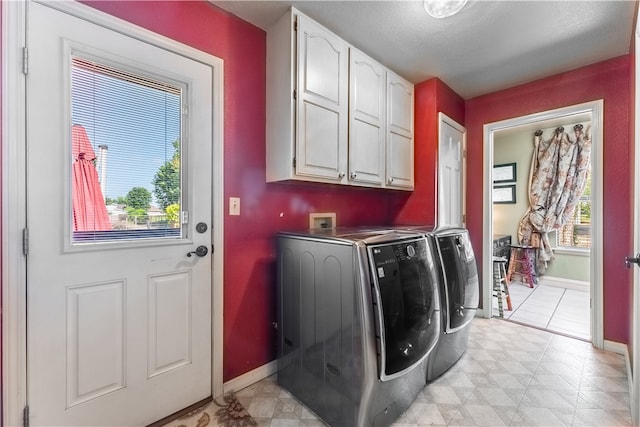 laundry room featuring cabinets, independent washer and dryer, and light tile patterned floors