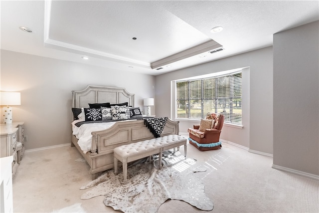 bedroom featuring a raised ceiling and light colored carpet