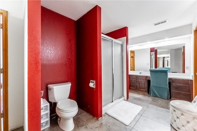 bathroom featuring vanity, tile patterned floors, a shower with door, and toilet