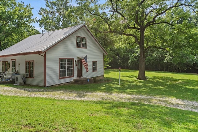 exterior space featuring metal roof and a front lawn