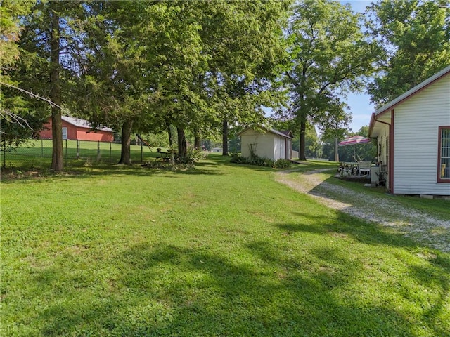 view of yard with an outbuilding and fence