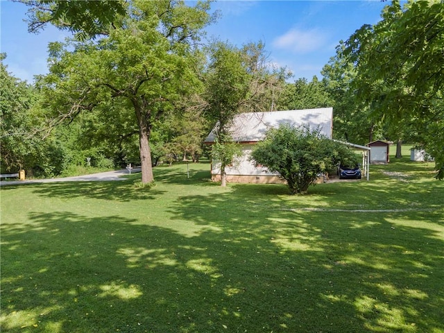 view of yard with a carport and an outbuilding