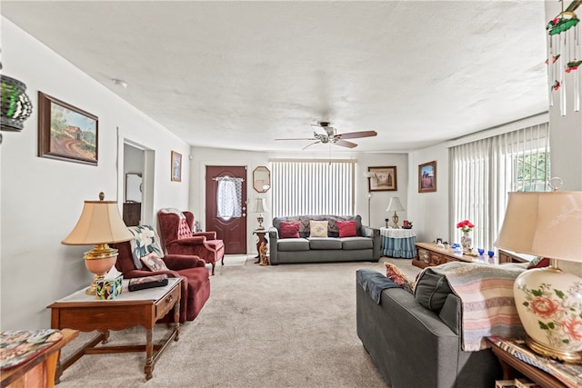 carpeted living room featuring a textured ceiling and ceiling fan