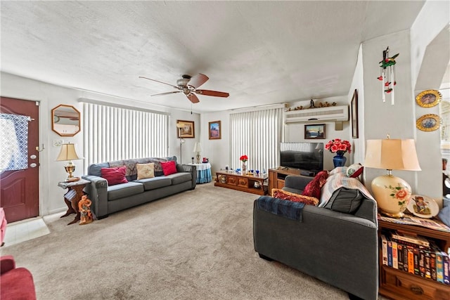 living area featuring a ceiling fan, carpet flooring, and a textured ceiling