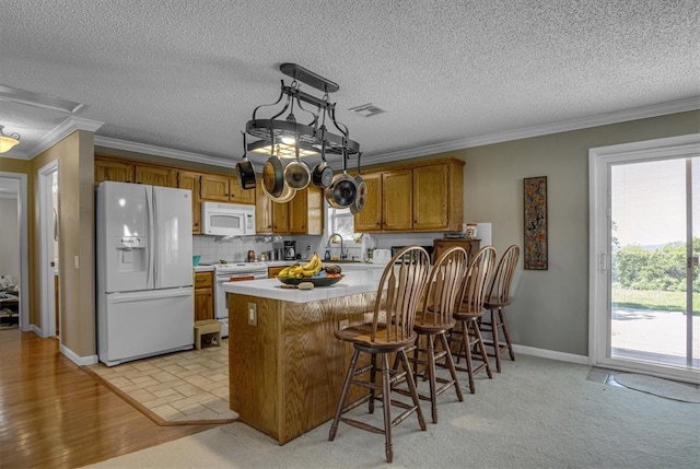 kitchen with tasteful backsplash, light carpet, white appliances, and kitchen peninsula