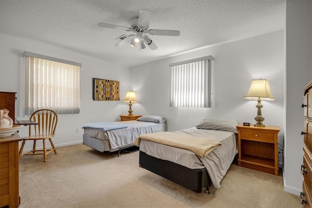 carpeted bedroom with a textured ceiling and ceiling fan