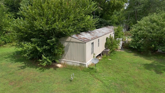 view of outdoor structure featuring central AC unit and a yard