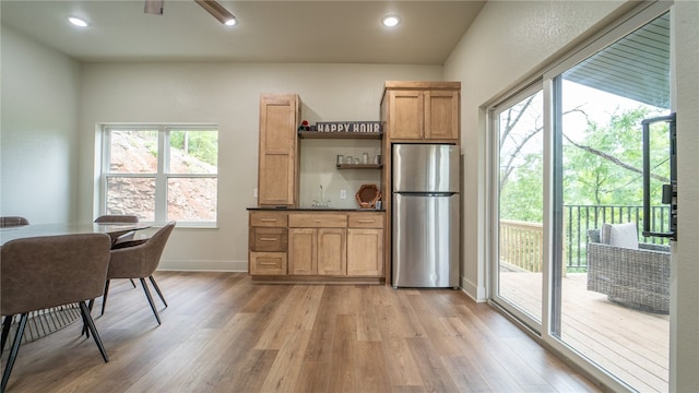 kitchen featuring light hardwood / wood-style floors, stainless steel refrigerator, and sink